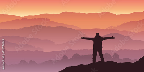 Fotografía Un homme alpiniste, contemple le soleil qui se lève à l'horizon d'une chaine de montagne
