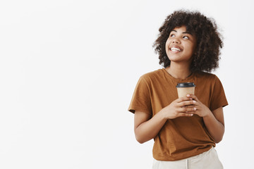 Wall Mural - studio shot of romantic dreamy good-looking girl with afro hairstyle in brown t-shirt holding paper 