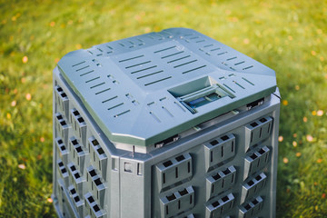 Wall Mural - compost bin on green grass background