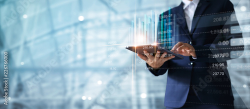 Fotografía Businessman using tablet analyzing sales data and economic growth graph chart