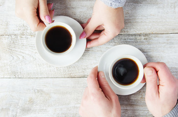 Wall Mural - Cups with a coffee in the hands of men and women. Selective focus.