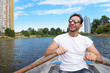 © Антон Зимин - A handsome muscular bearded man in sun glasses and white t shirt is driving a boat on a river or lake. Beautiful happy  guy swimming in a boat on a warm sunny day feeling free enjoying life