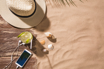 Top view of sandy beach with towel frame and summer accessories. Background with copy space and visible sand texture. Right border made of towel