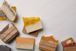 top view of various handmade soap pieces on white marble surface