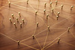 © killykoon - Linking entities. Network, networking, social media, internet communication abstract. A small network connected to a larger network. Web of gold wires on rustic wood.
