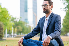 Close-up Of Calm Businessman Sitting In The Park Meditating
