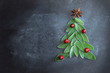 Fresh leaves of saffron lie on a dark background in the shape of a Christmas tree with cranberries