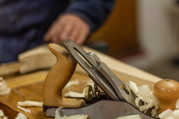 Eco friendly woodworker's shop. Details and focus on the texture of the material, saw dust, and planers or chisels, while making legs for a designer coffee table. Mastering wood with peacefullness.