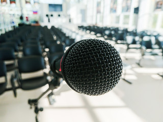 Black dynamic microphone on the background of the audience without people. Blurred background.