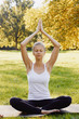 © Olesia - Girl meditates while practicing yoga outdoors in park