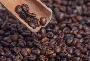 Wall Mural - Coffee grains are poured from a wooden owl on the table.