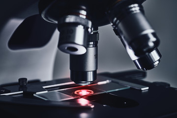 Close-up shot of modern microscope with sample slide at laboratory.