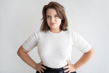 Smiling Chubby Girl Posing In Studio. Portrait Of Confident Young Woman Standing With Hands On Her Hips.  Beauty Concept