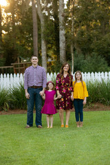 Wall Mural - Family of Four Holding Hands Outside of Home with White Picket Fence