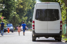 Back View White Passenger Medium Size Commercial Luxury Minibus Van Parked On Summer City Street.