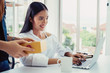 © Mymemo - Business owner concept. Young two asian woman smiling happy using laptop working and checking customer product packaging for online order in modern home office