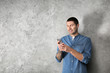 © Africa Studio - Young man in casual clothes using cell phone on light background