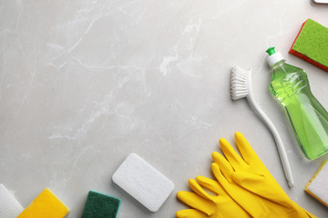 Flat lay composition with cleaning supplies for dish washing and space for text on grey background