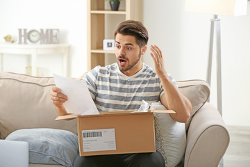 Wall Mural - Young man unpacking parcel at home