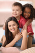 Young woman with little kids indoors. Child adoption