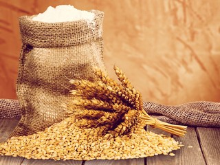 Wall Mural - Wheat ears and flour on wooden desk