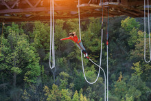 Women Jumping Down Bungee Jump Sport In Sunset And Light Flare