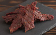 Pile of Black Pepper Beef Jerky on a Rustic Wooden Table