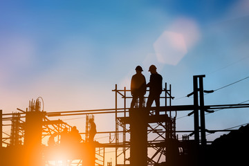 Silhouette of engineer and construction team working at site over blurred background for industry background with Light fair.Create from multiple reference images together