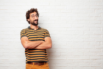 Wall Mural - young dumb man with a proud, satisfied and happy look on face, smiling with arms crossed