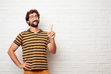 young dumb man smiling and looking satisfied and happy, counting number with one finger.