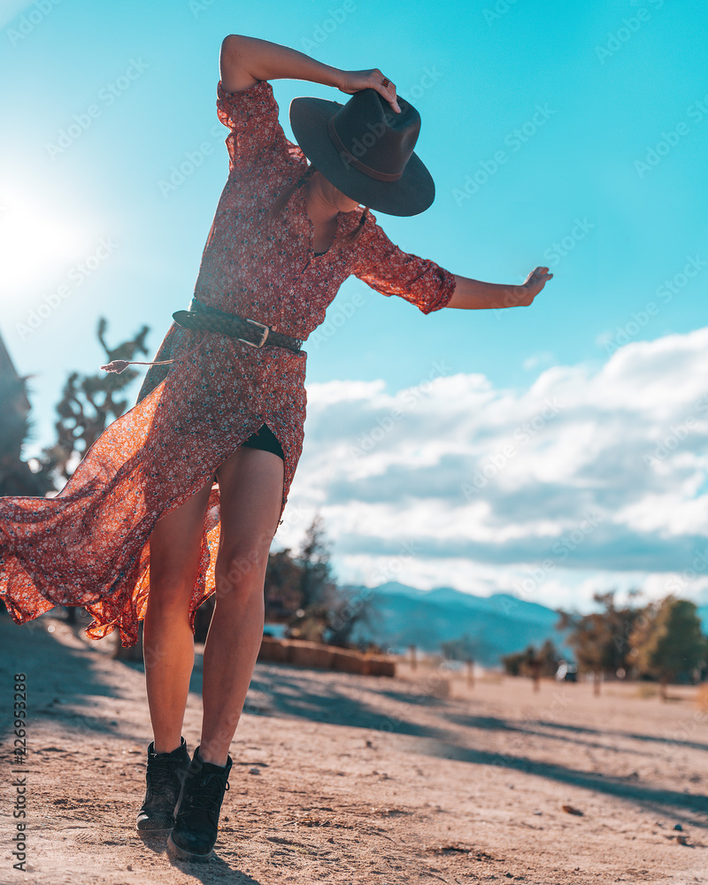 Girl with hat and red dress dancing in the desert Stock Photo | Adobe Stock