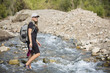 © Brocreative - Attractive Woman hiking across a shallow mountain stream while on vacation in the Western United States. Candid photo of an active female enjoying the outdoors