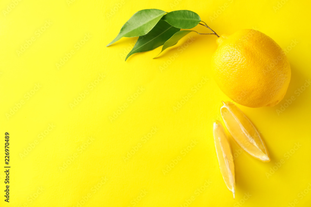Ripe whole lemon and slices on color background