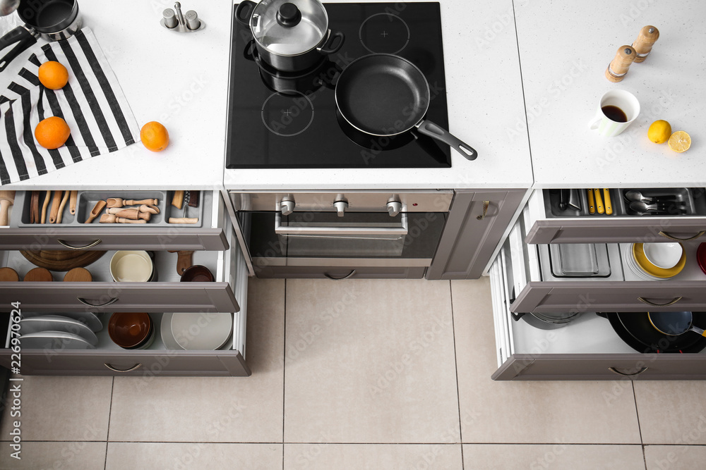 Set of clean kitchenware in open drawers