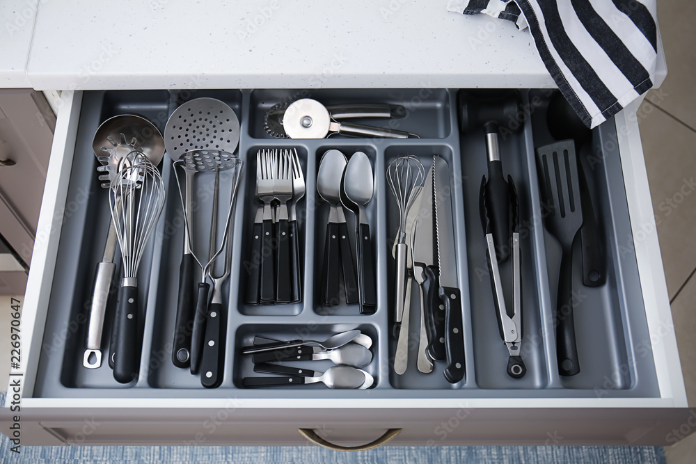 Set of clean kitchen utensils in drawer
