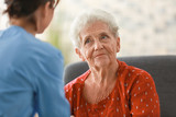 Fototapeta  - Young nurse visiting elderly woman at home