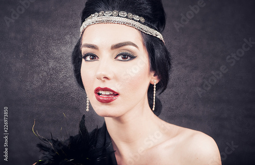 Fotografia, Obraz Sensual brunette closeup with twenties retro look on black glowing background