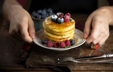 Poster - man serves a plate of homemade punkcakes and berries