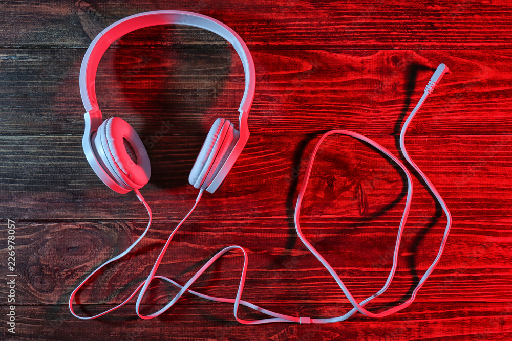 Modern headphones on wooden background