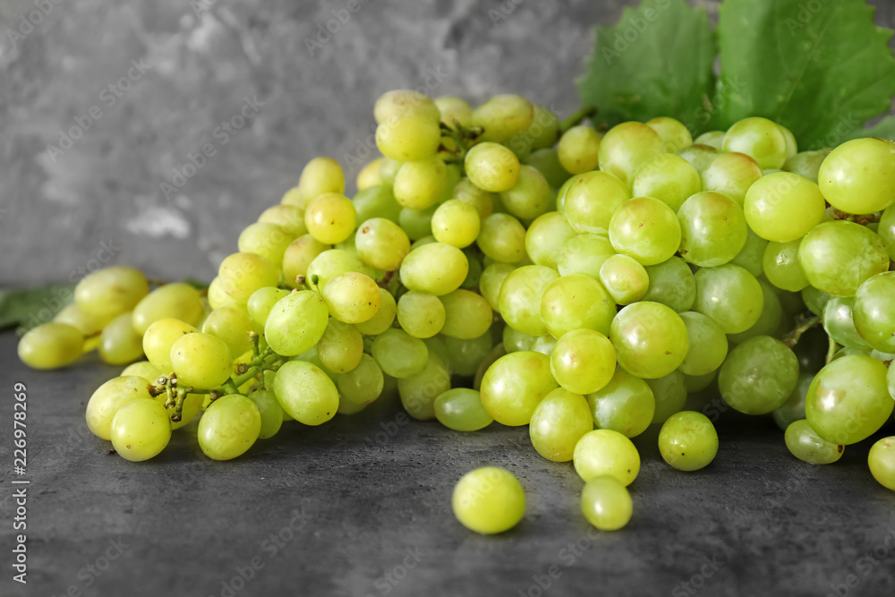 Ripe juicy grapes on grey table