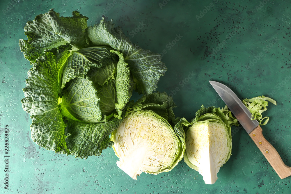 Whole and cut savoy cabbages on color table