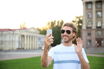 Sticker - Handsome young man taking selfie in park