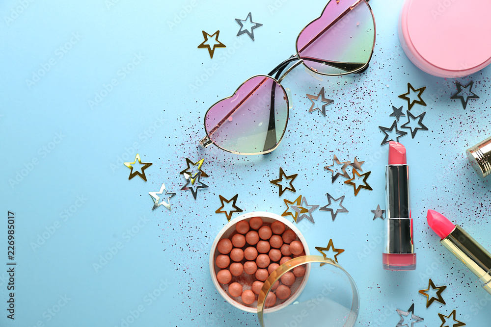 Set of decorative cosmetics with sunglasses on color background