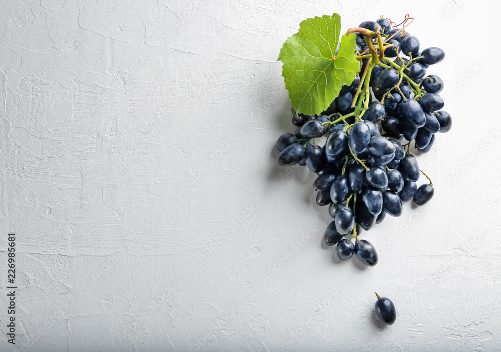Ripe sweet grapes on white textured background, top view