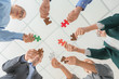 © Pixel-Shot - Business team with pieces of puzzle in office, bottom view