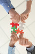 © Pixel-Shot - Business team with pieces of puzzle in office, bottom view