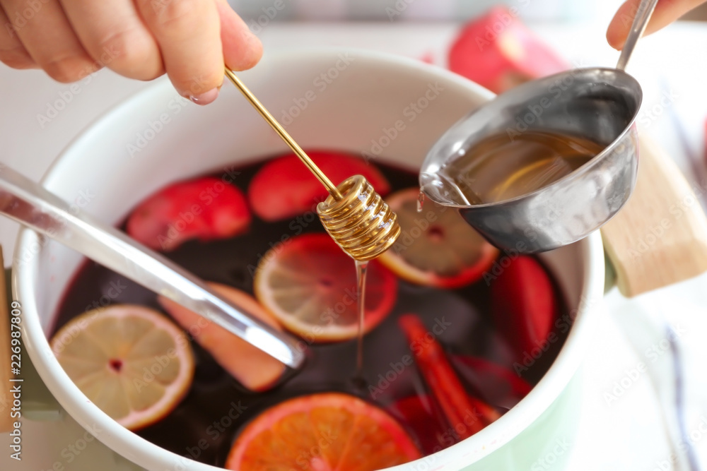 Woman preparing mulled wine, closeup
