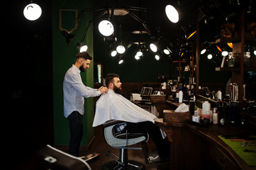 Wall Mural - Handsome bearded man at the barbershop, barber at work.