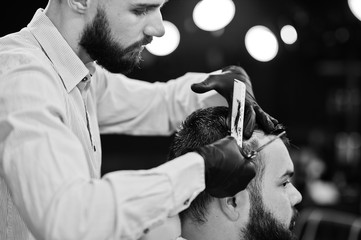 Wall Mural - Handsome bearded man at the barbershop, barber at work.