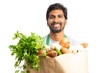 © Thunderstock - Male indian employee holding paper bag with groceries.